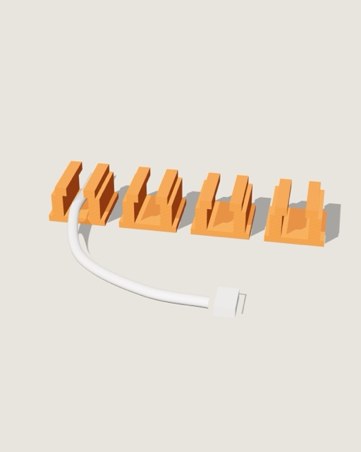Vier oranje kabelclips met een laadkabel